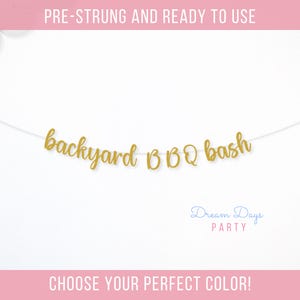 May include: A gold glitter banner that reads "backyard BBQ bash" strung on a white string. The banner is ready to use and is perfect for a summer party. The text "Dream Days Party" is also visible.