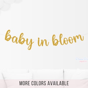 May include: Gold glitter banner with the text "baby in bloom".