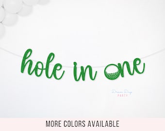 May include: A green glitter "hole in one" banner, perfect for a golf-themed party. The banner is strung on a white string and features a golf ball graphic. Additional colors are available.