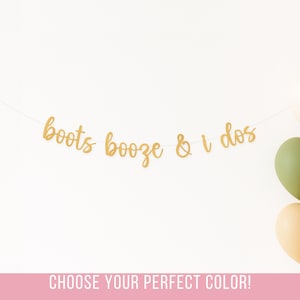 以下が含まれることがあります： 白い背景に、「boots booze & i dos」と書かれた金色のバナーが吊り下げられています。クリーム、ラスト、オリーブ、ゴールドの色合いの5つの風船が右側に集まっています。「CHOOSE YOUR PERFECT COLOR！」というテキストが下にあります。