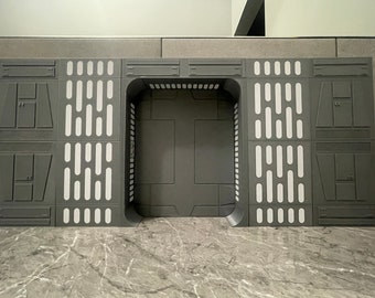 May include: A gray and white Star Wars themed playset with a large doorway and a panel of rectangular lights on each side.
