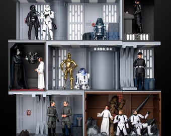 Puede incluir: Una vitrina de varios niveles con figuras de acción de Star Wars. El nivel superior presenta un Stormtrooper, Darth Vader y un piloto rebelde. El nivel intermedio presenta a C-3PO, R2-D2 y un piloto de caza TIE. El nivel inferior presenta a Chewbacca, la princesa Leia y tres Stormtroopers.