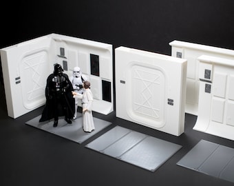Puede incluir: Un conjunto de separadores de habitación de plástico blanco con temática de Star Wars con tres figuras: Darth Vader, un Stormtrooper y la princesa Leia. Las figuras están de pie sobre un suelo gris.