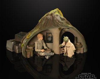 May include: A diorama of a scene from Star Wars: The Book of Boba Fett, featuring Luke Skywalker and Yoda. Luke is sitting on a stool, holding a tool, while Yoda is standing in front of him, holding a walking stick. The diorama is made of plastic and is scaled for the Star Wars: The Black Series action figures.
