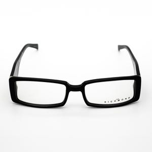 May include: Black rectangular eyeglasses with a black frame and clear lenses. The brand name "RICHMOND" is printed on the right lens.