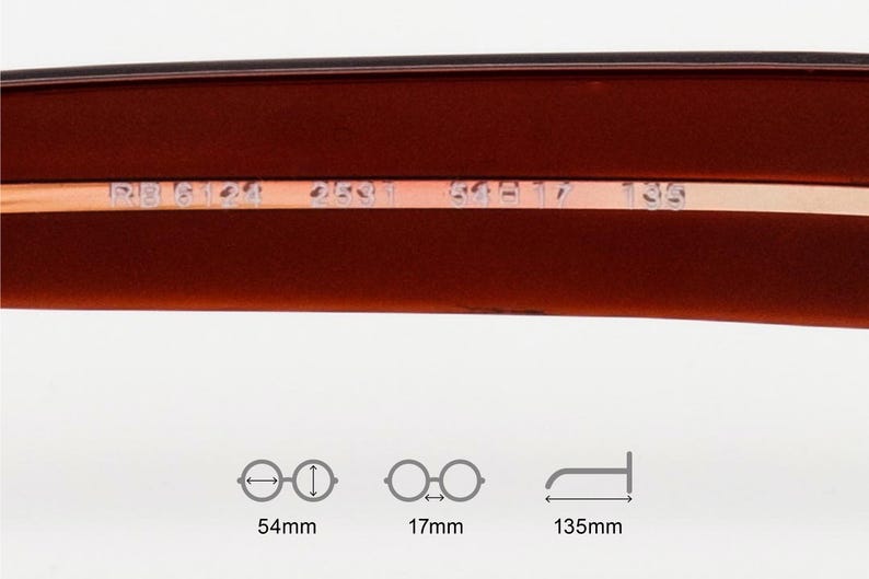 May include: Close-up of the inner frame of eyeglasses. The frame is a dark reddish-brown colour with a thin, metallic gold-coloured strip. The text "RB 6124 2531 59 17 135" is printed on the gold strip. The image includes diagrams with measurements: 54mm, 17mm, and 135mm.