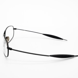 K&ouml;nnte beinhalten: Schwarze Metallgestellbrille mit schwarzen Kunststoffb&uuml;geln.