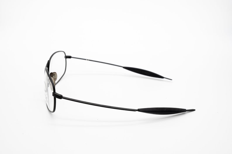 K&ouml;nnte beinhalten: Schwarze Metallgestellbrille mit schwarzen Kunststoffb&uuml;geln.