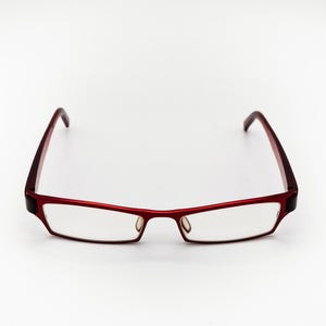 May include: Red eyeglasses with a rectangular frame and clear lenses.