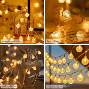 Puede incluir: Luces de cadena con bombillas esf&eacute;ricas transparentes que iluminan varios entornos. La imagen muestra las luces sobre una jaula decorativa, un busto, una figura de reno y colgadas en una habitaci&oacute;n. El texto en la imagen dice "Home Improvement", "Room Decor", "Holiday Decor" y "Hanging Lights".