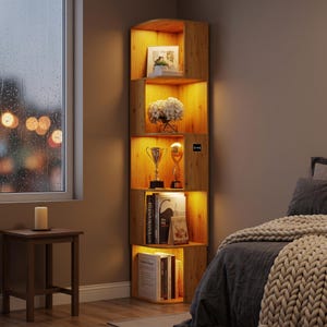 May include: A tall, light-brown wooden corner shelf unit with five open tiers. Each shelf is illuminated by integrated warm LED lighting. The unit displays various items including books, a white floral arrangement, and two metallic trophies.