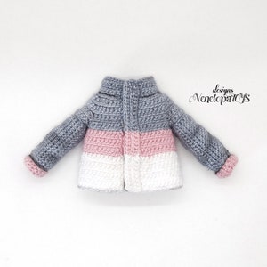 May include: A gray, pink, and white crocheted jacket with a zipper closure. The jacket has a striped pattern and is made with a soft yarn.