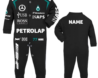 Puede incluir: Un mameluco negro de manga larga para bebé con gráficos de carreras en blanco y turquesa, incluyendo el texto PETROLAP, BOSS BABY y USB. La parte delantera tiene cierre de botones y la parte trasera muestra la palabra NAME en blanco.