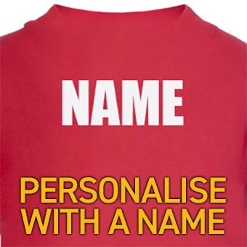 K&ouml;nnte beinhalten: Ein rotes T-Shirt mit dem Wort "NAME" in wei&szlig;en Blockbuchstaben. Unter dem Wort "NAME" steht der Text "PERSONALISIEREN SIE MIT EINEM NAMEN" in gelben Blockbuchstaben. Das T-Shirt ist einfarbig.