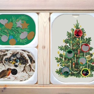 May include: A wooden display case with three oval-shaped trays. The top tray features a green background with Christmas ornaments. The middle tray shows a winter scene with birds. The bottom tray displays a decorated Christmas tree.