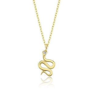 May include: A gold snake necklace with a small diamond accent. The snake is coiled and has a delicate design.