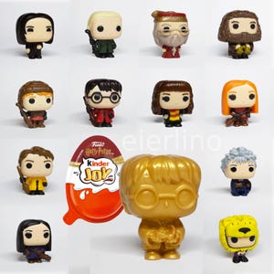 May include: A selection of Funko Pop figures depicting characters from the Harry Potter franchise. The figures include characters such as Snape, Draco Malfoy, and Harry Potter. A Kinder Joy egg with Harry Potter branding is also present.