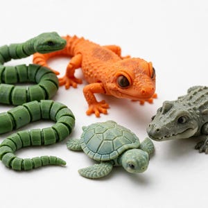 May include: A collection of four articulated animal figures including a green segmented snake, a bright orange lizard with textured skin, a small green sea turtle with a patterned shell, and a grey crocodile with a detailed scaly back and limbs.