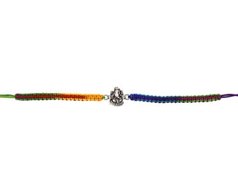 May include: A colorful macrame bracelet featuring a silver-toned charm of a deity. The bracelet is made of woven threads in green, red, yellow, blue, and purple. The charm is centered on the bracelet.