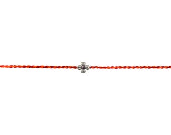 May include: A minimalist bracelet featuring a silver-colored four-leaf clover charm centered on a thin, bright orange cord. The cord is a vibrant, eye-catching color, and the charm has a detailed, textured appearance. The bracelet is set against a plain white background.