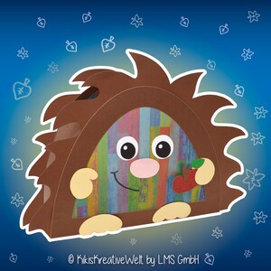 May include: A brown paper craft hedgehog with a colorful striped background, a pink nose, and black eyes. The hedgehog is holding a red apple with a green leaf.