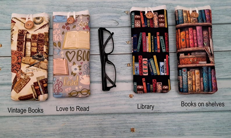 Puede incluir: Cuatro estuches rectangulares de tela para gafas con cierre de bot&oacute;n, con estampados de libros antiguos, libros abiertos con el texto Love to Read, estanter&iacute;as de biblioteca y libros en estantes, junto a unas gafas negras.