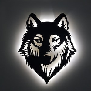 Pode incluir: Uma silhueta preta de uma cabeça de lobo com uma luz branca brilhando atrás. Os olhos do lobo são visíveis e a pelagem é detalhada.