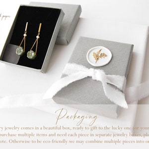 May include: A gray jewelry box with a white ribbon and a wax seal with a gold leaf design. The text "Packaging" is written in cursive on the box. The text "Every jewelry comes in a beautiful box, ready to gift to the lucky one (or yourself!). If you purchase multiple items and need each piece in separate jewelry boxes, please leave me a note. Otherwise to be eco-friendly we may combine multiple pieces into one box." is written below the box.