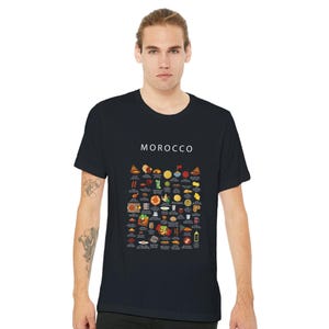 T-shirt featuring a colorful illustration of traditional Moroccan foods, including a steaming tagine, fluffy couscous, bowl of harira soup, fresh mint tea, and assorted sweet pastries, styled in a vibrant street-food design