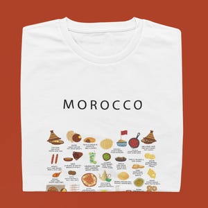T-shirt featuring a colorful illustration of traditional Moroccan foods, including a steaming tagine, fluffy couscous, bowl of harira soup, fresh mint tea, and assorted sweet pastries, styled in a vibrant street-food design