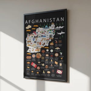 Pode incluir: Um poster emoldurado com um mapa do Afeganistão com ilustrações de comida, pontos de referência e elementos culturais. A palavra "AFGHANISTAN" está no topo. O poster está numa moldura preta e é exibido numa parede branca.
