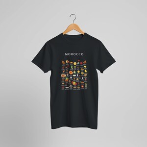 T-shirt featuring a colorful illustration of traditional Moroccan foods, including a steaming tagine, fluffy couscous, bowl of harira soup, fresh mint tea, and assorted sweet pastries, styled in a vibrant street-food design