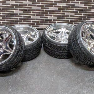 Pode incluir: Quatro rodas de liga leve cromadas com pneus pretos. As rodas t&ecirc;m um design em forma de estrela no centro e um acabamento polido. Os pneus t&ecirc;m um padr&atilde;o de piso.