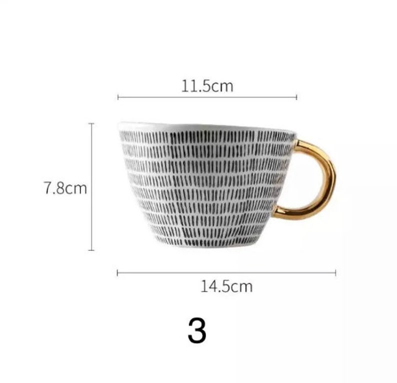 May include: White ceramic mug with a black and white geometric pattern and a gold handle. The mug is 7.8 cm tall, 11.5 cm wide, and 14.5 cm long.