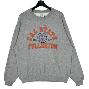 Könnte beinhalten: Grauer Sweatshirt mit einer orangefarbenen und blauen Grafik, auf der "CAL STATE FULLERTON" steht, sowie einem kreisförmigen Logo mit der Aufschrift "CALIFORNIA STATE UNIVERSITY EST. 1957" in blauer Schrift.