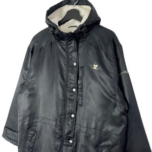 May include: Black hooded jacket with a fleece lining. The jacket has a zipper closure and a button placket. The jacket has a logo on the left chest and the word "omega" on the right sleeve.