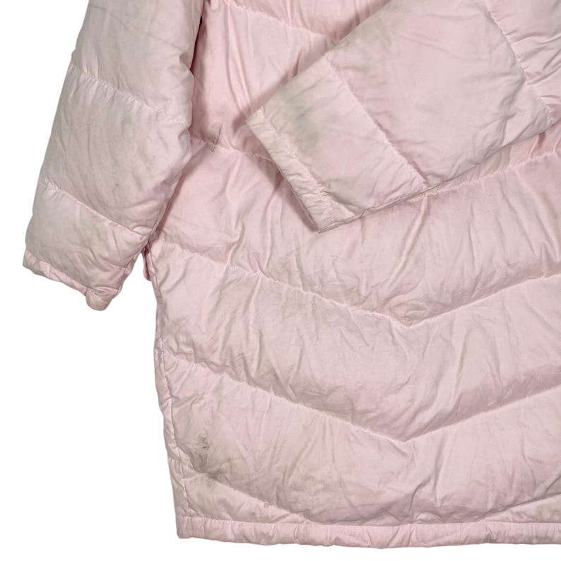 K&ouml;nnte beinhalten: Eine rosafarbene Steppjacke mit gestepptem Design. Die Jacke hat einen Rei&szlig;verschluss und eine Kapuze.