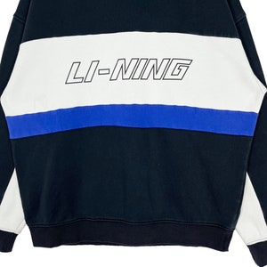 May include: Black and white striped sweatshirt with a blue stripe and the text "LI-NING" in black.