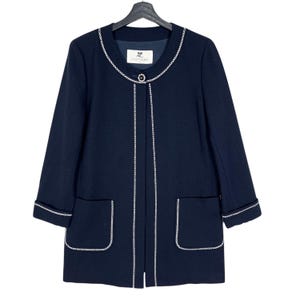 May include: A navy blue long-sleeved jacket with white trim around the neckline, pockets, and hem. The jacket has a single button closure and a label that reads "Courr&egrave;ges".