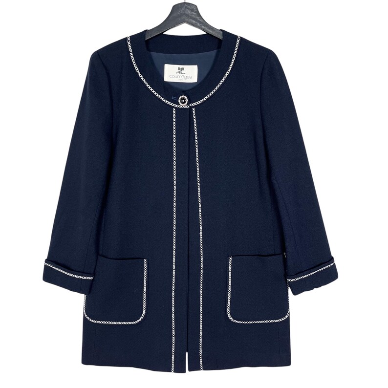 May include: A navy blue long-sleeved jacket with white trim around the neckline, pockets, and hem. The jacket has a single button closure and a label that reads "Courr&egrave;ges".