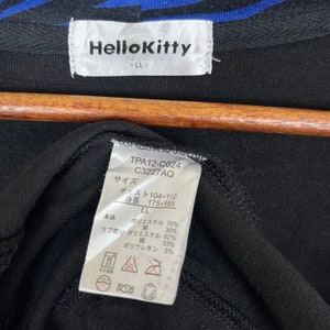 May include: Black Hello Kitty long-sleeve shirt with blue and white stripes on the collar. The tag says "Hello Kitty" and "LL" and includes size and fabric details in Japanese.