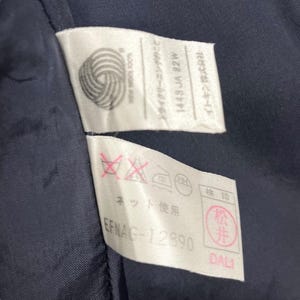 May include: White care label with black text that reads "Dry Cleaning Only" and "1448 JA 82W" and "Itokin Corporation". A second white label with black text that reads "Net Use" and "EFNAG-12890". A red label with white text that reads "松井".