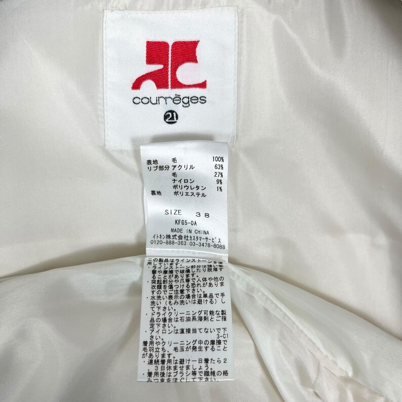 May include: A white garment tag with the Courr&egrave;ges logo in red and the number 21. The tag includes fabric composition details, size 38, and care instructions in Japanese. Made in China.