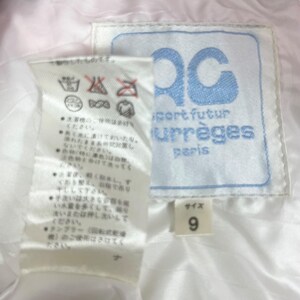 K&ouml;nnte beinhalten: Wei&szlig;es Etikett mit japanischem Text und Pflegehinweisen. Ein blaues Etikett mit dem Text "Sport futur Courr&egrave;ges Paris" und ein wei&szlig;es Etikett mit dem Text "Gr&ouml;&szlig;e 9".