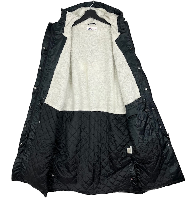 May include: A black long-sleeved jacket with a hood, lined with white fleece and a quilted interior. The jacket has a button closure and multiple pockets.