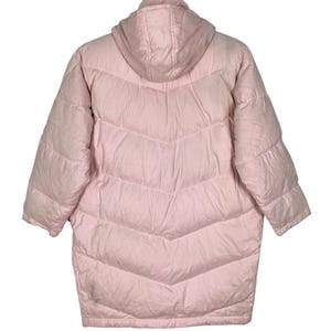 K&ouml;nnte beinhalten: Eine rosafarbene Daunenjacke mit Kapuze und Steppdesign. Die Jacke hat eine lange L&auml;nge und eine lockere Passform.