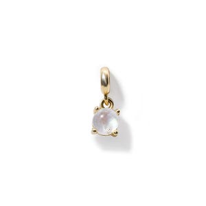 May include: A gold charm with a round, white moonstone pendant.