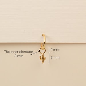 Pu&ograve; includere: Orecchino a cerchio in oro con un piccolo ciondolo a forma di cactus. Il cerchio ha un diametro interno di 3 mm e il ciondolo &egrave; alto 6 mm. Il diametro interno del cerchio &egrave; di 3 mm e il ciondolo &egrave; alto 6 mm.