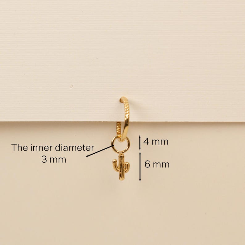 Pu&ograve; includere: Orecchino a cerchio in oro con un piccolo ciondolo a forma di cactus. Il cerchio ha un diametro interno di 3 mm e il ciondolo &egrave; alto 6 mm. Il diametro interno del cerchio &egrave; di 3 mm e il ciondolo &egrave; alto 6 mm.