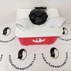 May include: A red and white cooler with a black fan and two white elbow-shaped vents. The cooler has a penguin logo and the text "chilloutswampcoolers.com" is printed on the surrounding surfaces.